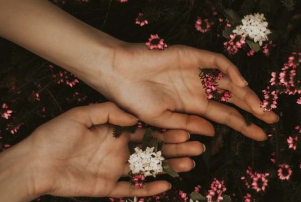 hands resting in flowers